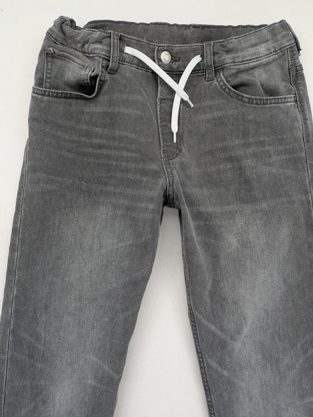 H&M grey jogger jeans with elastic waistband and drawstring, stylish washed look.