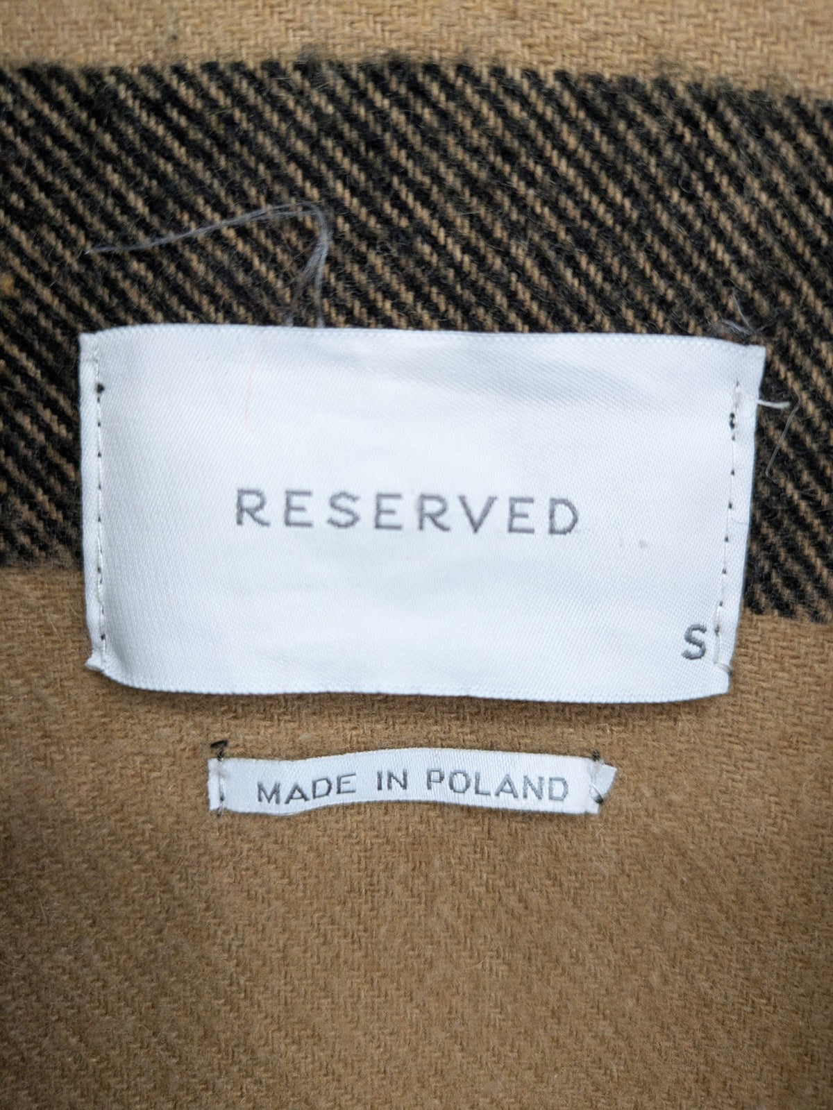 Reserved cream coat with brown and black check pattern, fringe hem, wool blend material.