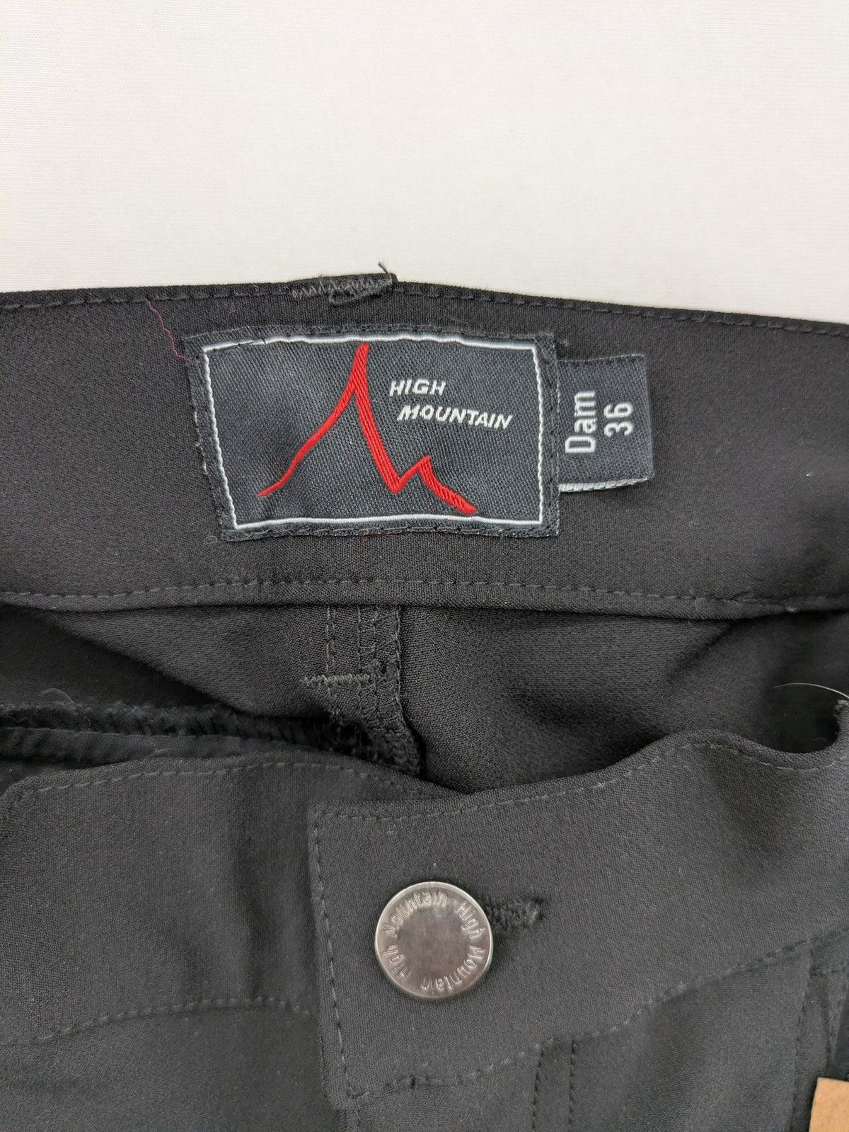 High Mountain black cargo pants with multiple pockets and durable stretch material.
