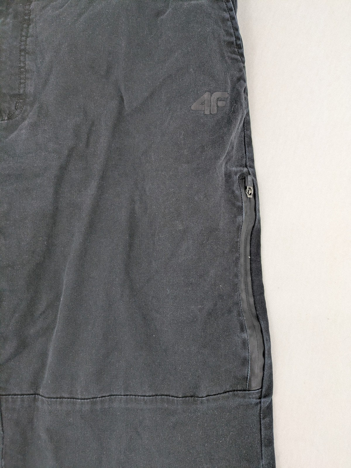 4F black cargo pants with reinforced knees, made from cotton-stretch material.