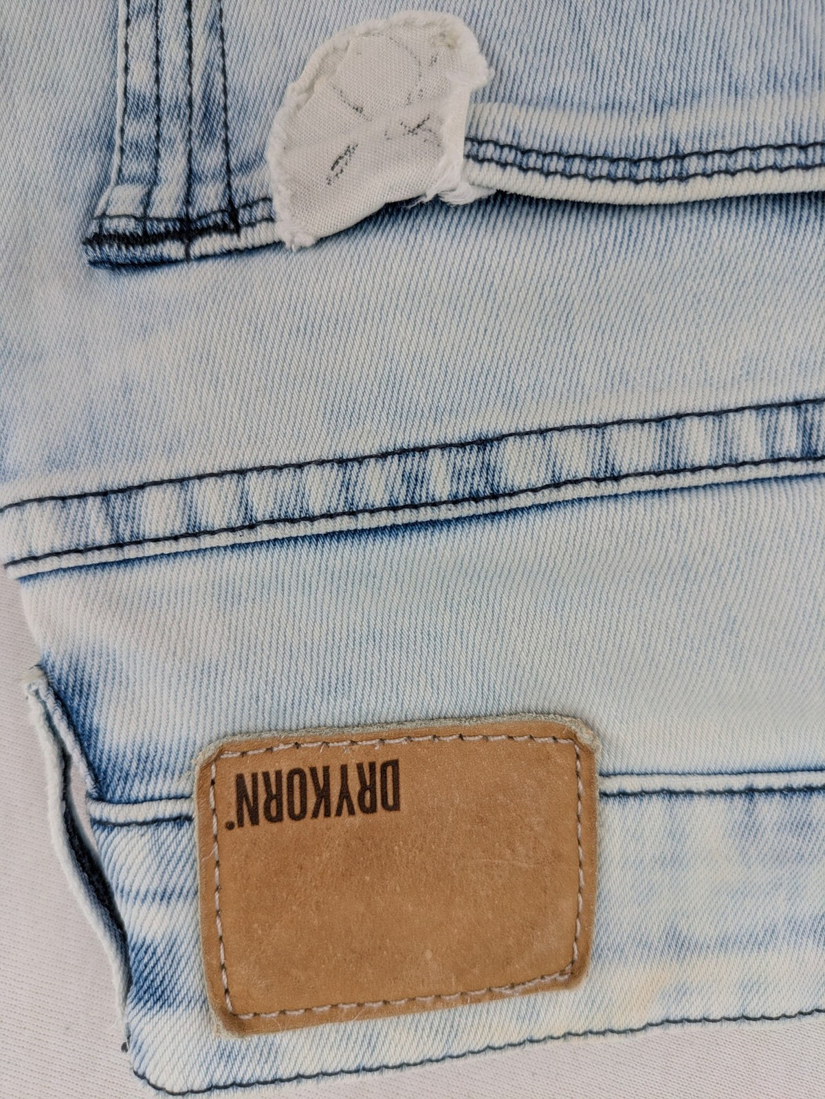 Drykorn blue slim fit jeans with acid wash and leather logo patch.