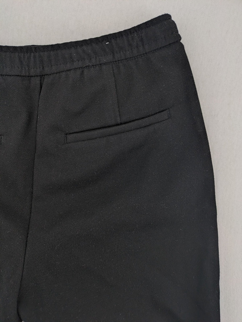 Zara black shorts with elastic drawstring, pleats, and rolled hem detail.