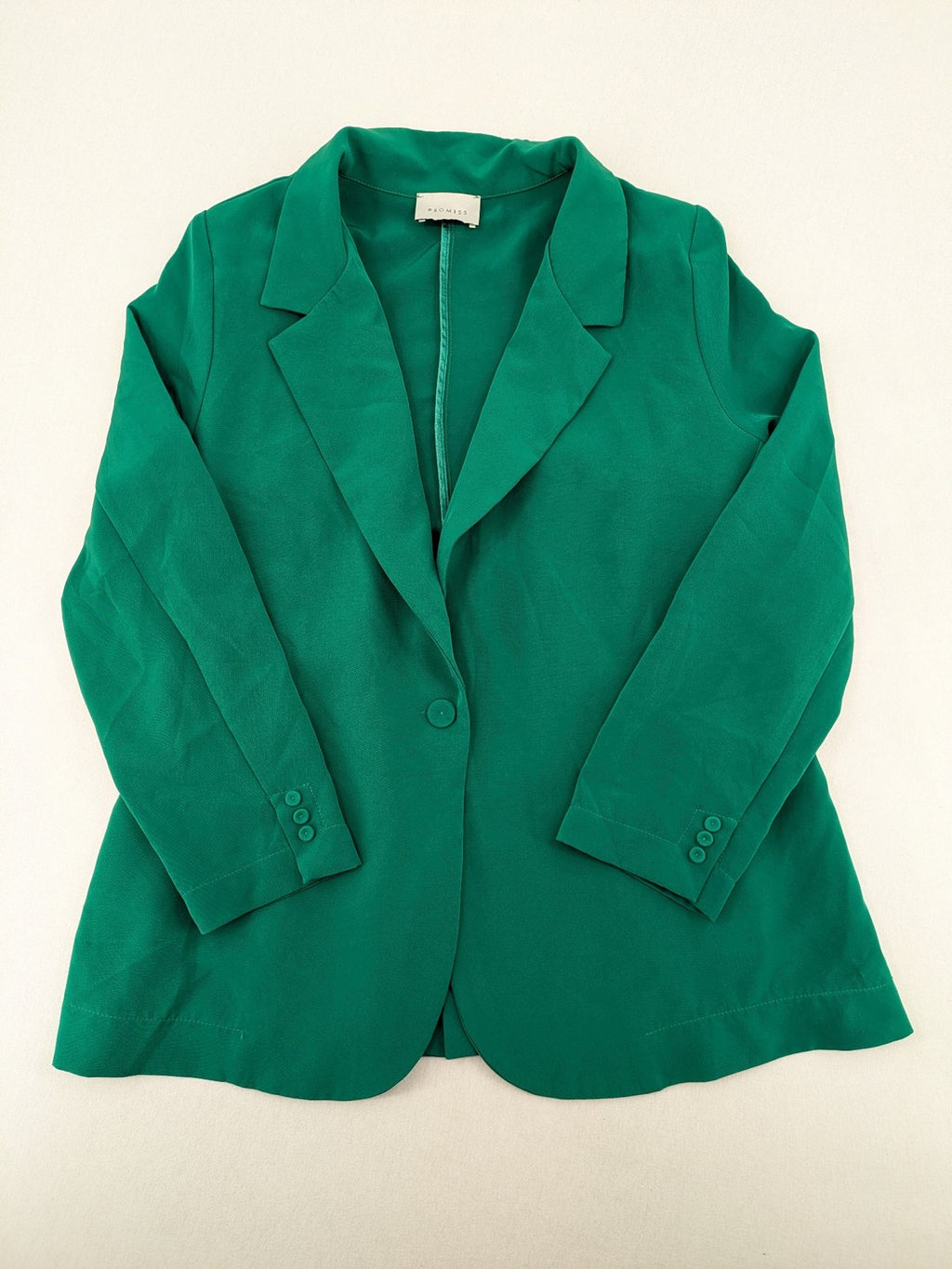 Promiss green blazer jacket single-button design with notch lapels and decorative pockets.