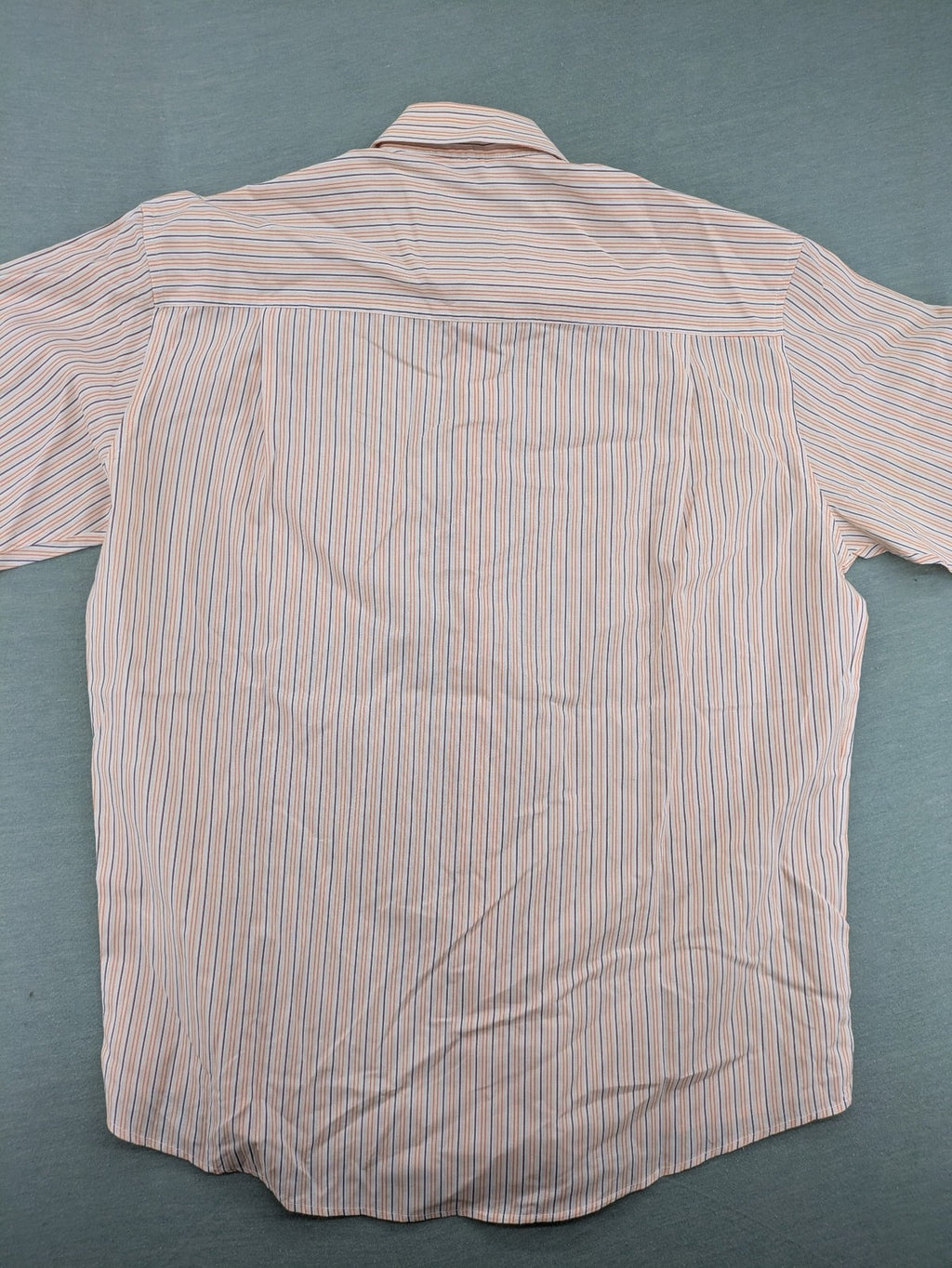 Ken Baker orange short-sleeve shirt with vertical stripes and chest pocket.