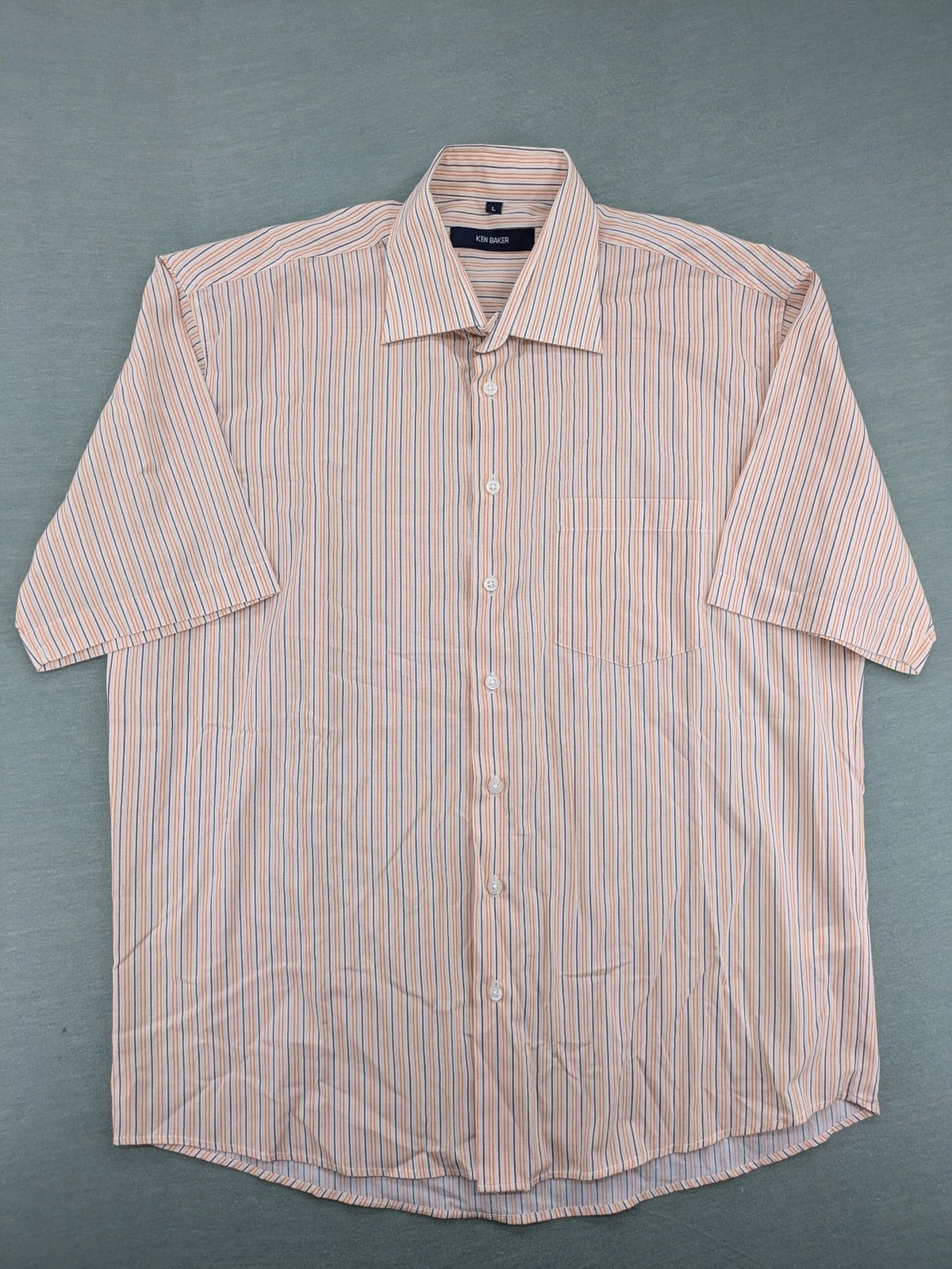 Ken Baker orange short-sleeve shirt with vertical stripes and chest pocket.