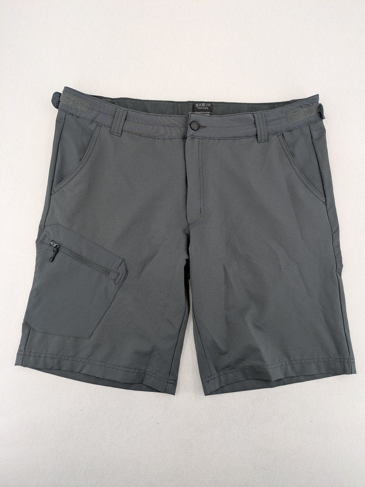 Outdoor grey functional shorts with adjustable velcro waistband and zippered leg pocket.