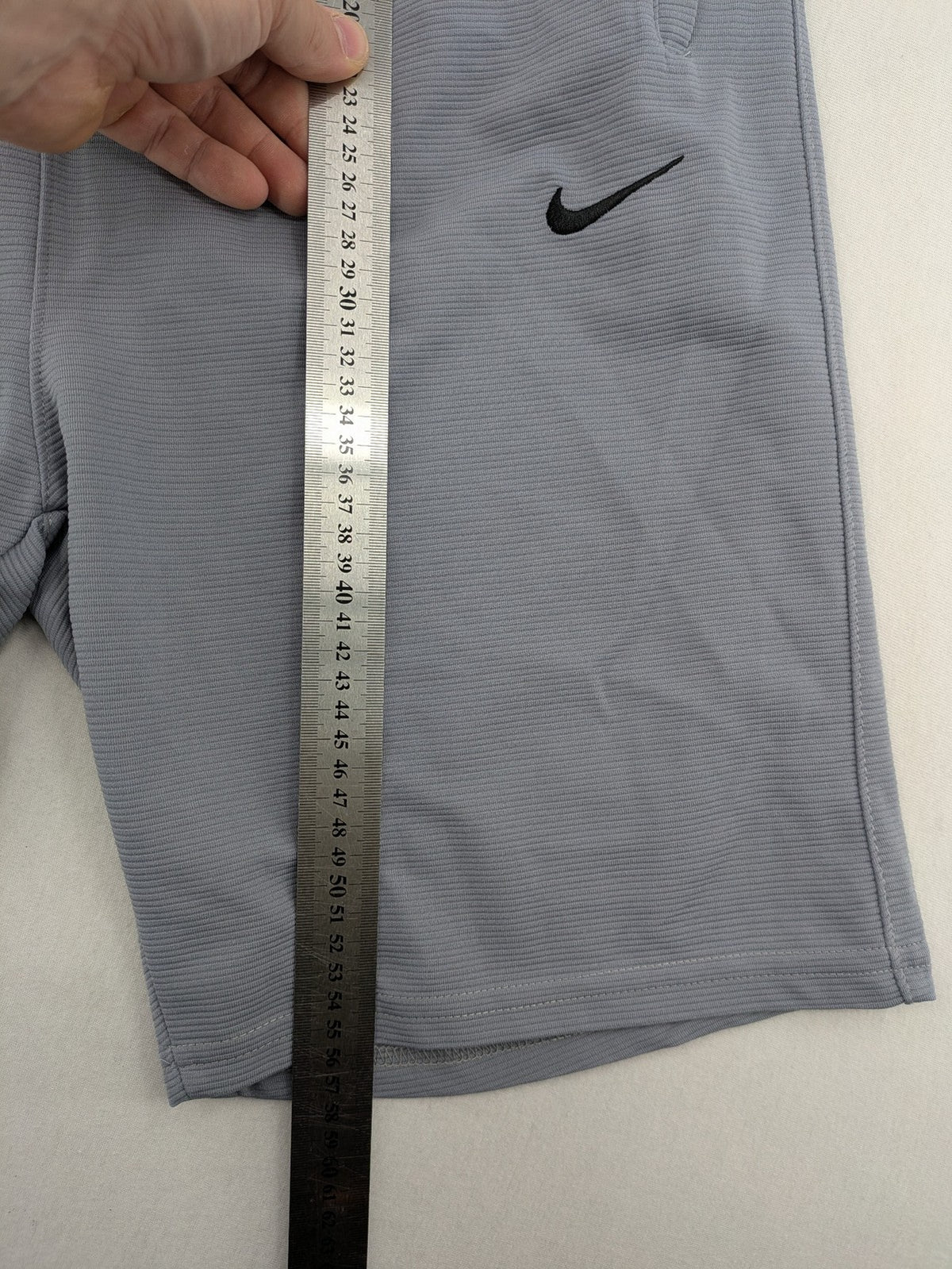 Nike grey shorts with Dri-FIT technology, elastic waistband, and zippered pockets.