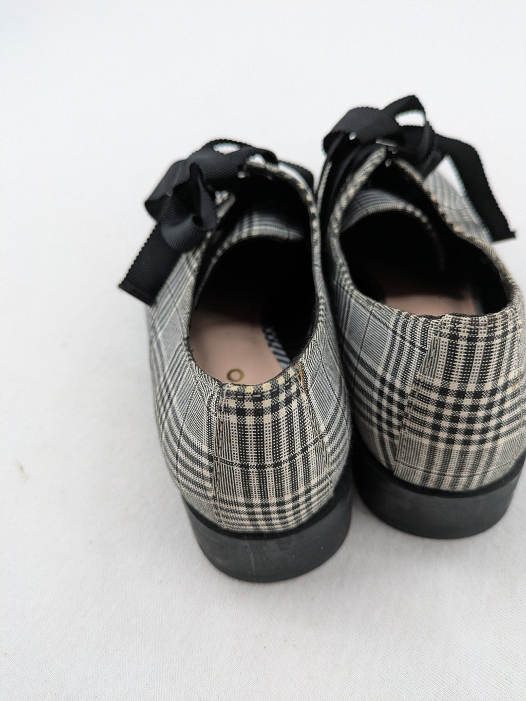 ALDO black and white checkered loafers with decorative bow detail and pointed toe.