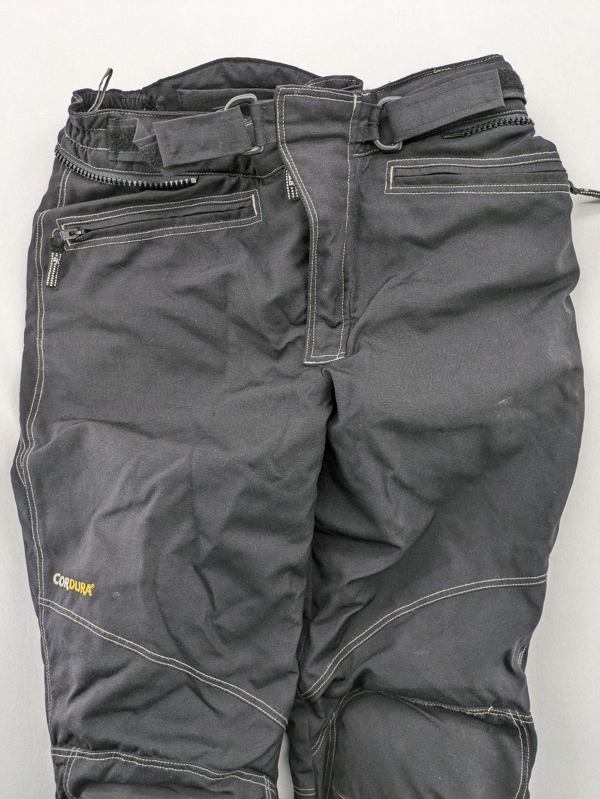 Rukka black motorcycle chaps with grey accents and CE knee protectors, made from durable Cordura.