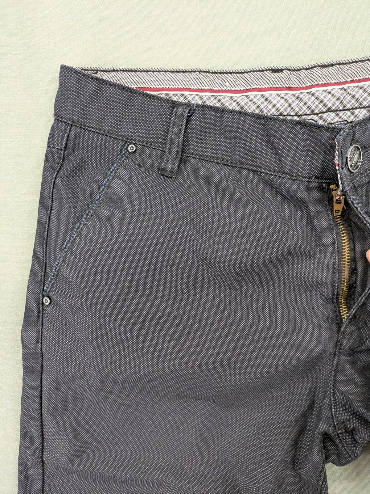 Rooney grey chino pants with checkered waistband and buttoned back pockets.