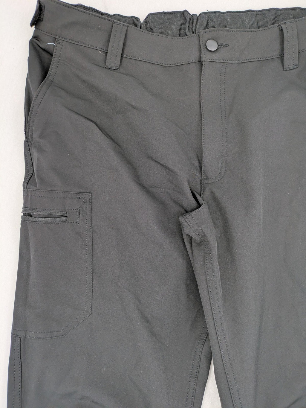 Outdoor grey trekking pants with zippered cargo pockets and durable stretch fabric.