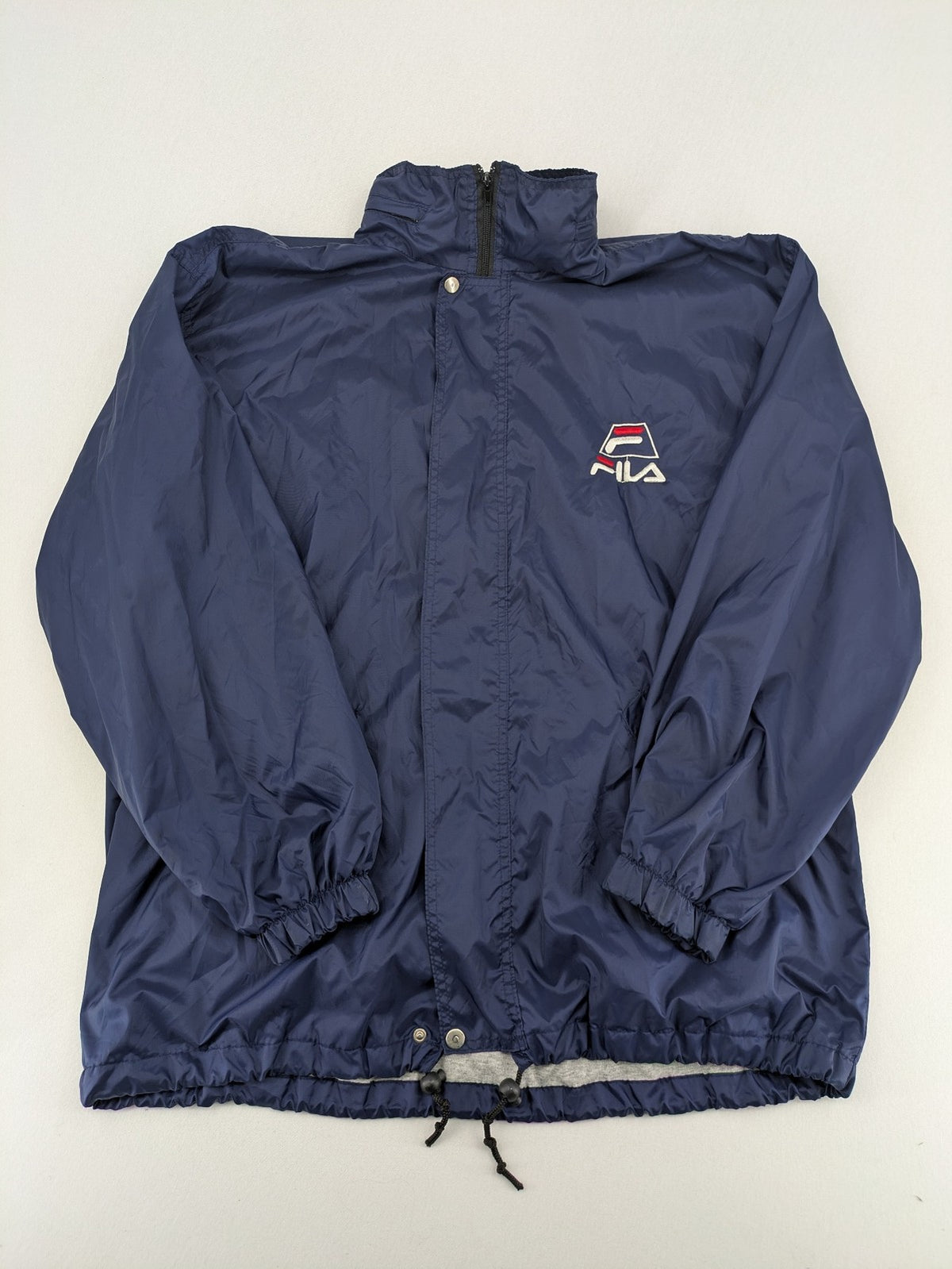 Fila navy windbreaker jacket with large embroidered logo on chest and back.