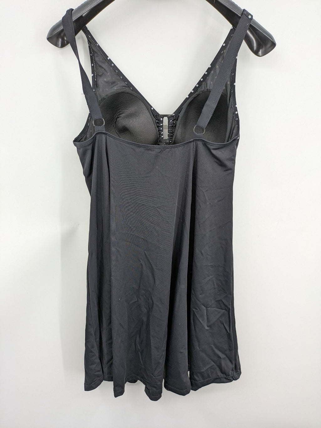 Elegante black swimsuit with white polka dots, V-neck, adjustable straps, and padded cups.