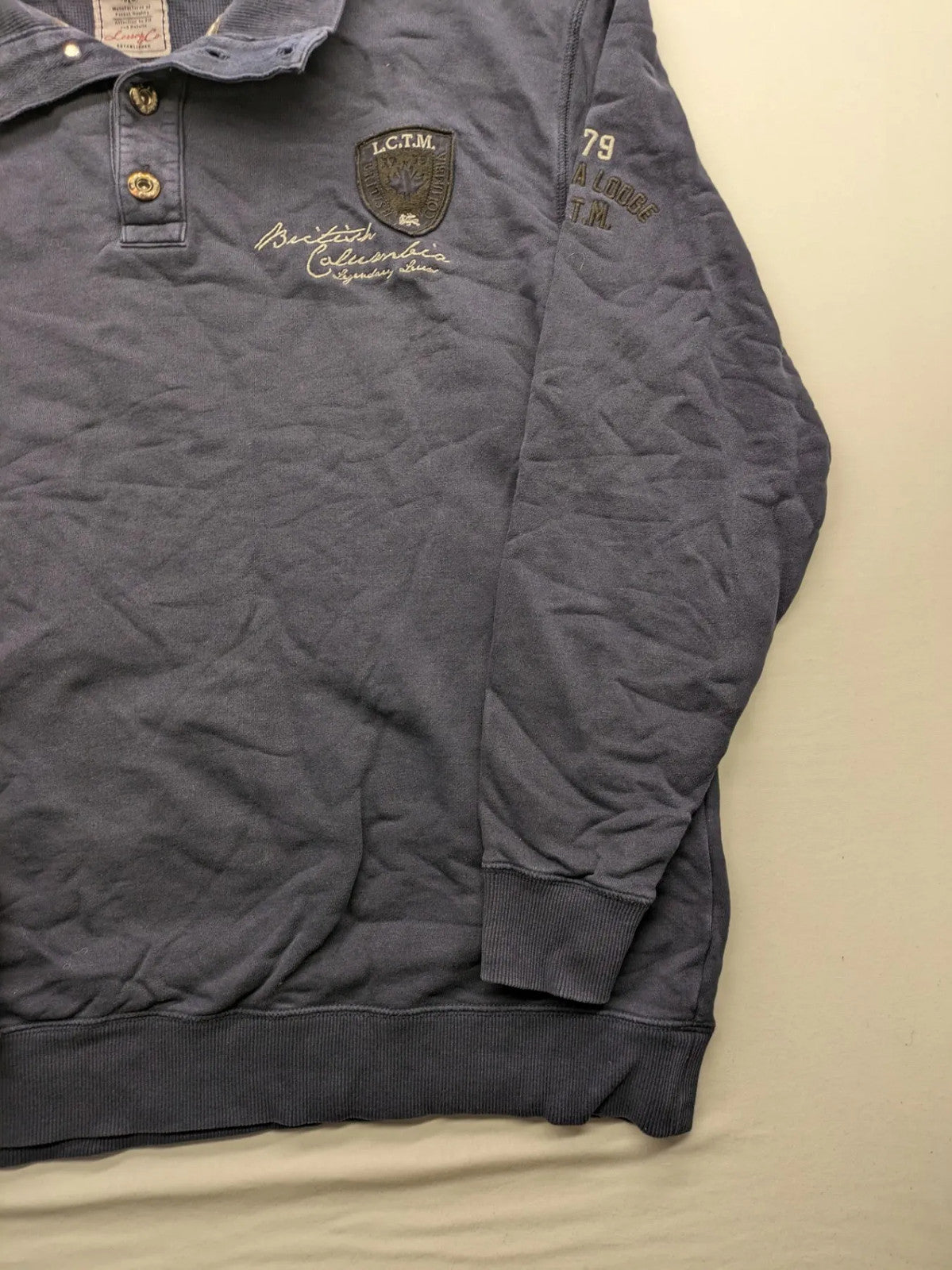 Lerros blue turtle neck jumper with stitched 'British Columbia' detail and button accents.