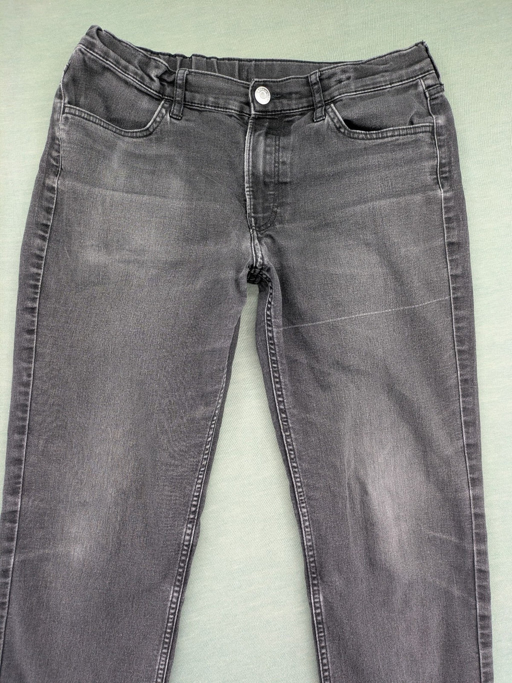 H&M grey slim fit jeans with adjustable waistband and faded wash detail.