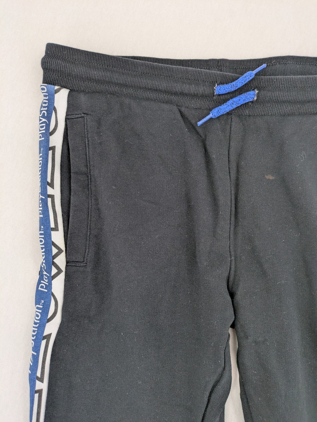 Baumwolle black pants with PlayStation logo tape, elastic waistband, cotton material.