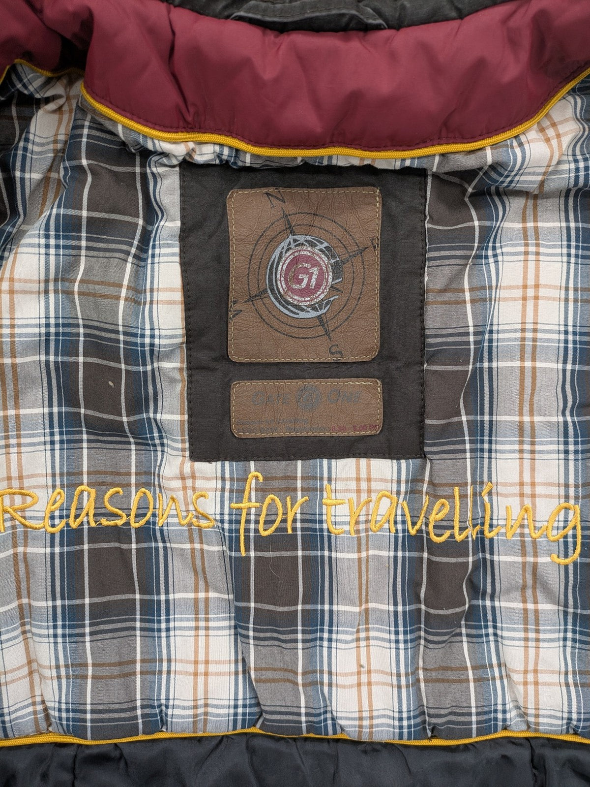 Gate One brown field jacket with plaid lining, multiple pockets, and zip-button closure.