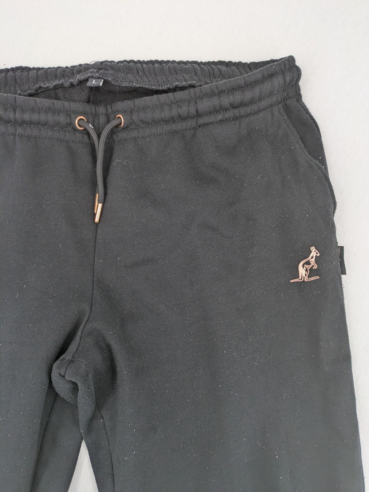 Kuyruun black jogging pants with kangaroo logo, elastic waistband, and ribbed cuffs.