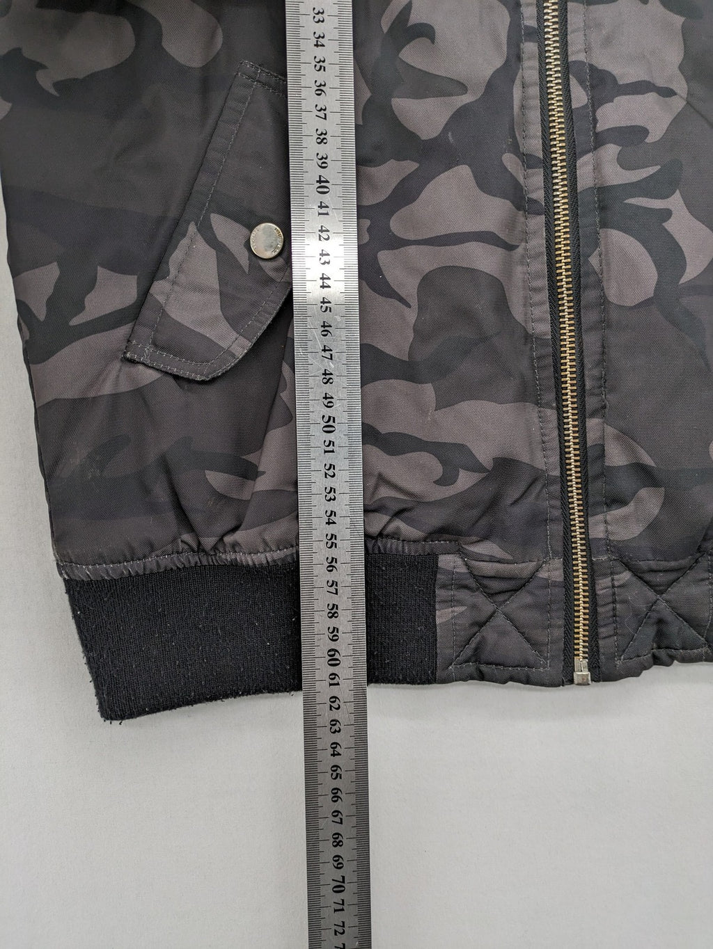 FB Sister orange bomber jacket with gray camouflage pattern and quilted lining.