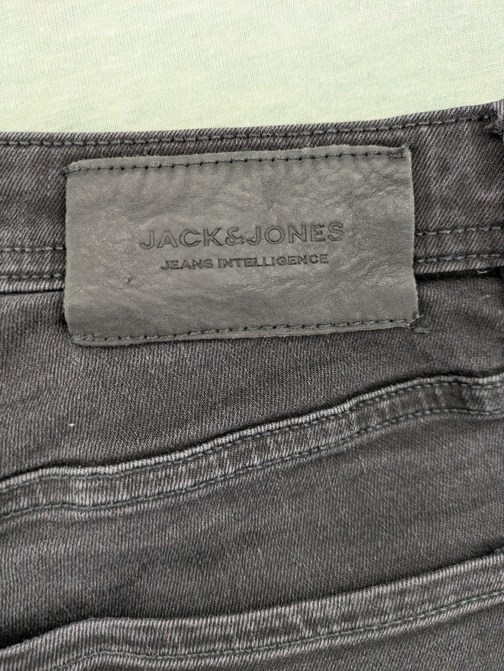 Jack & Jones black slim fit jeans faded wash stretch denim with logo detail.