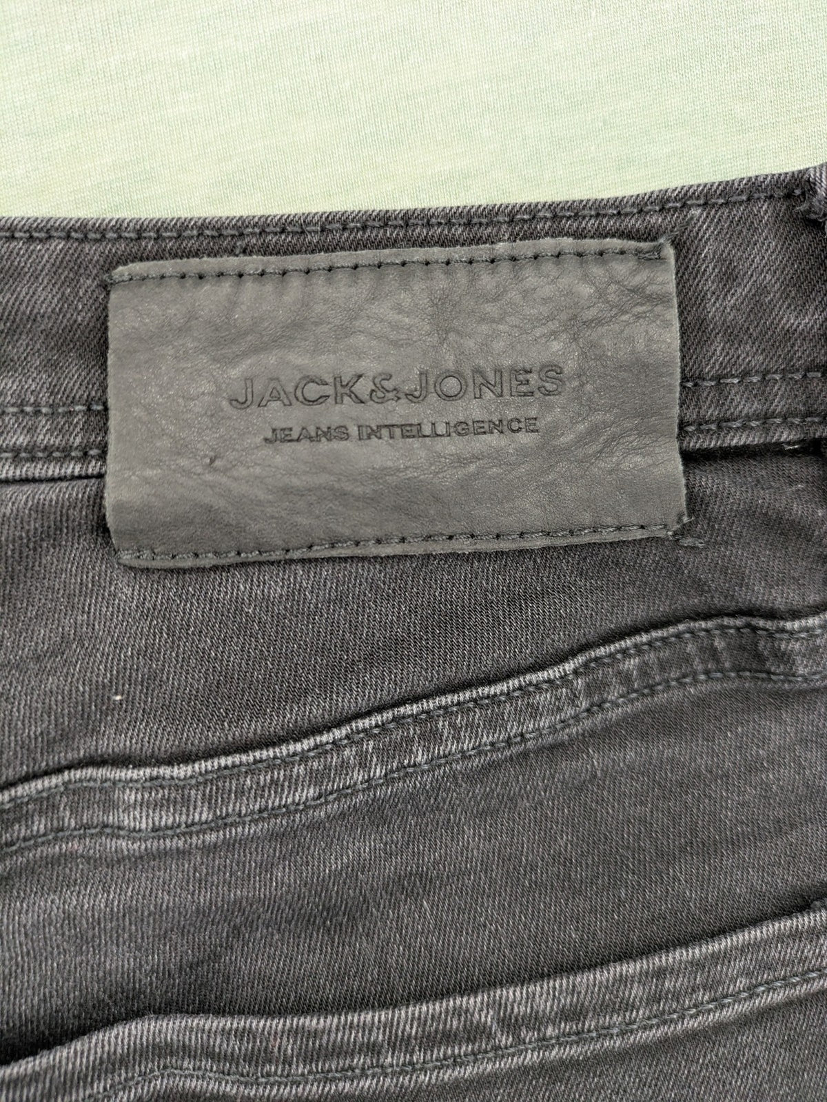 Jack & Jones black slim fit jeans faded wash stretch denim with logo detail.
