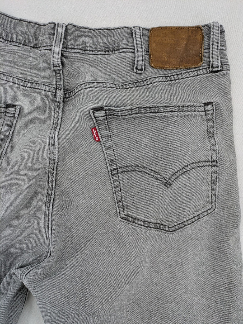 Levi's grey slim fit jeans with distressed knee details and classic logo patch.