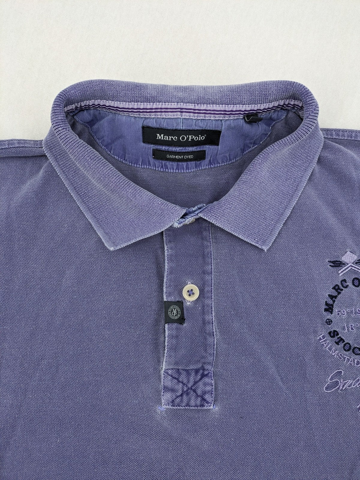 Marc O'Polo purple polo shirt garment dyed cotton with embroidered logo and intricate details.