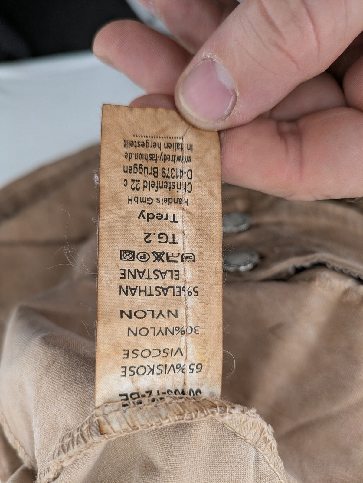 TREDY brown high-waist pants with decorative button placket and elastic waistband, soft knit texture.