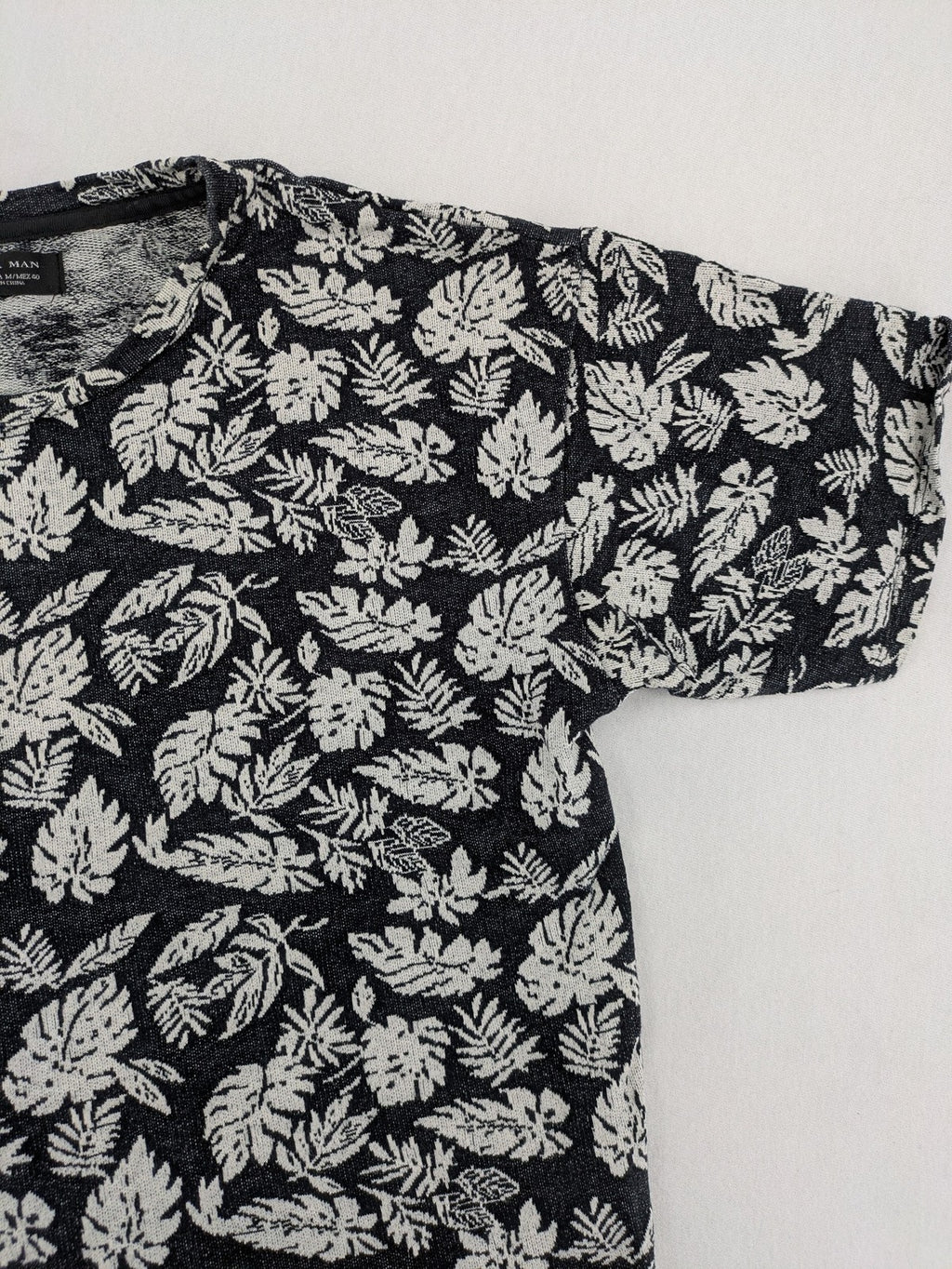 Zara Man black and white t-shirt with allover leaf print and textured knit fabric.