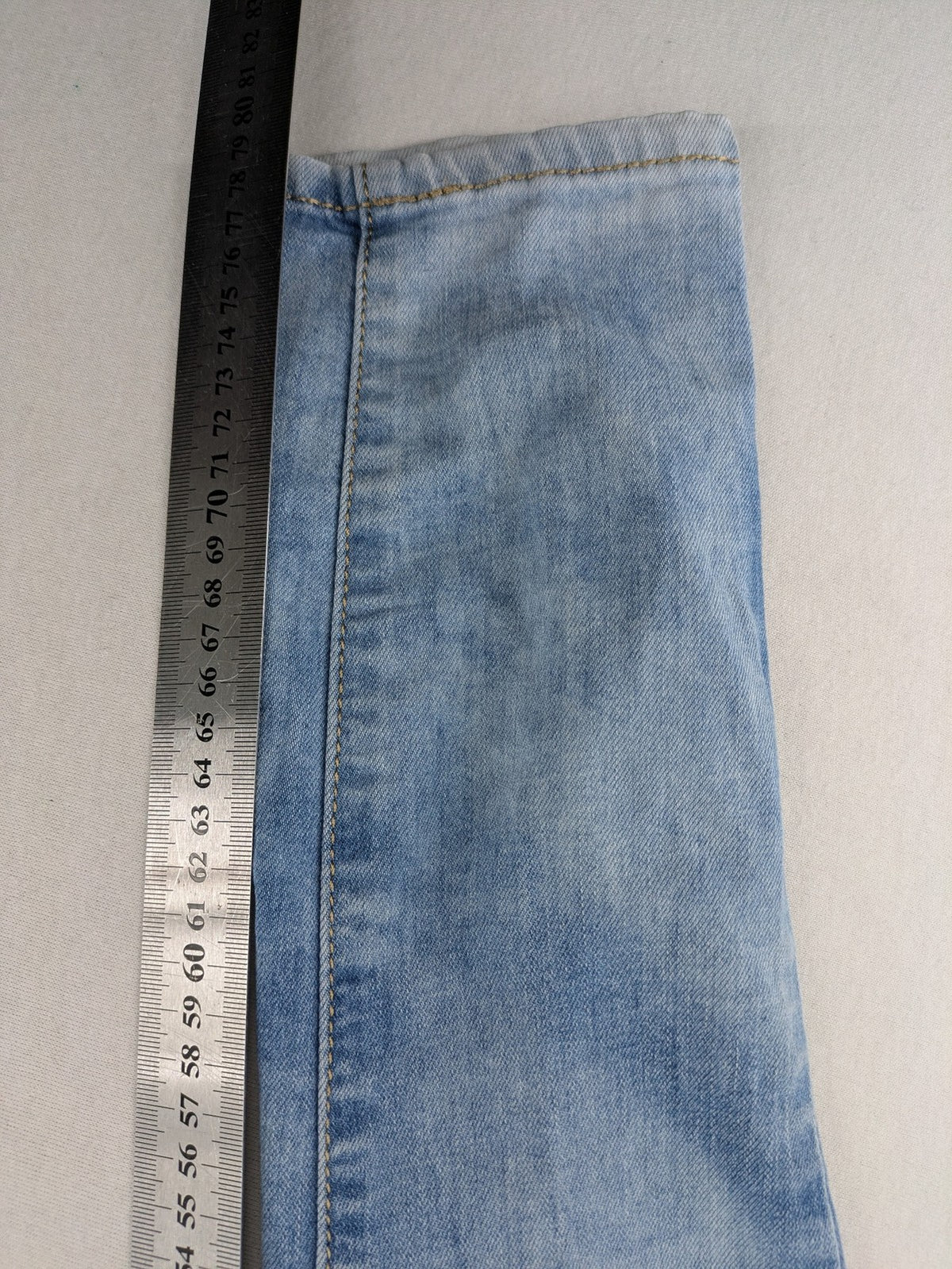Lexxury blue skinny jeans distressed with knee rips and light wash finish.