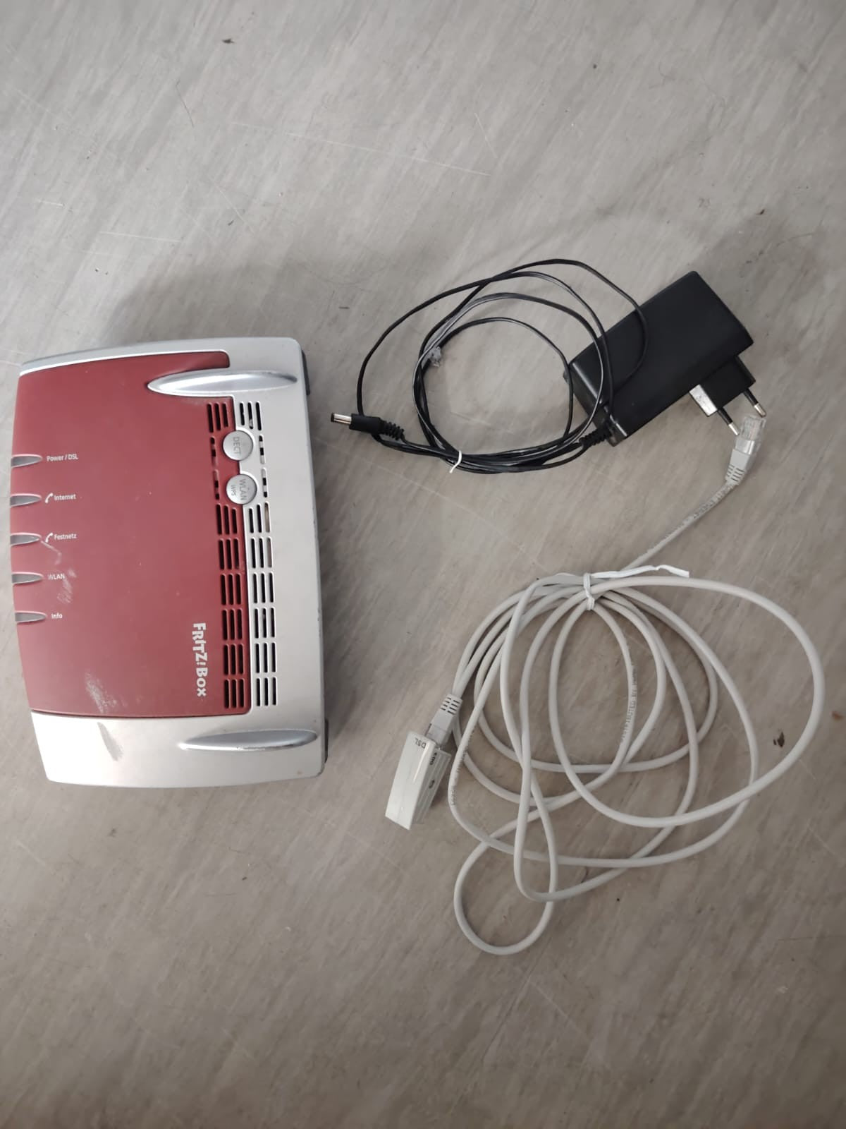 AVM wireless router grey and red with NetCologne logo and multiple connectivity ports.