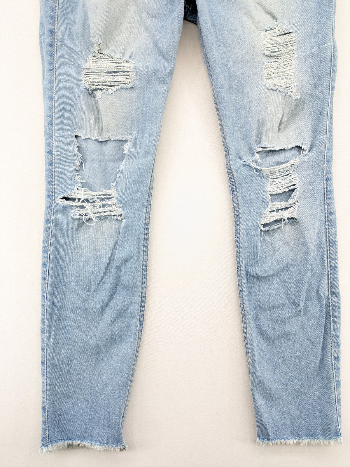 Hollister blue high-rise crop super skinny jeans with distressed rips and frayed hem.