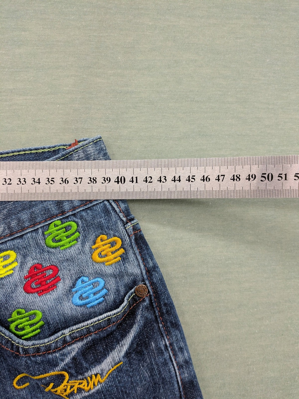 Y2K blue straight jeans with colorful logo embroidery and baggy fit.