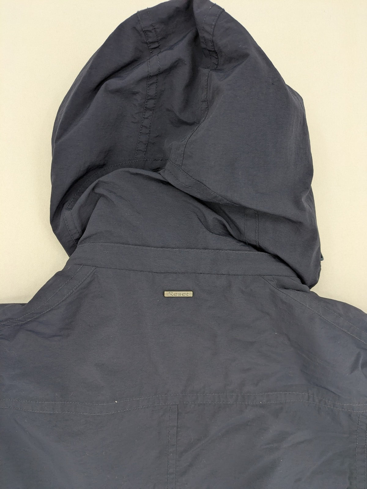 Reset navy parka jacket windproof with adjustable hood and zippered chest pocket.