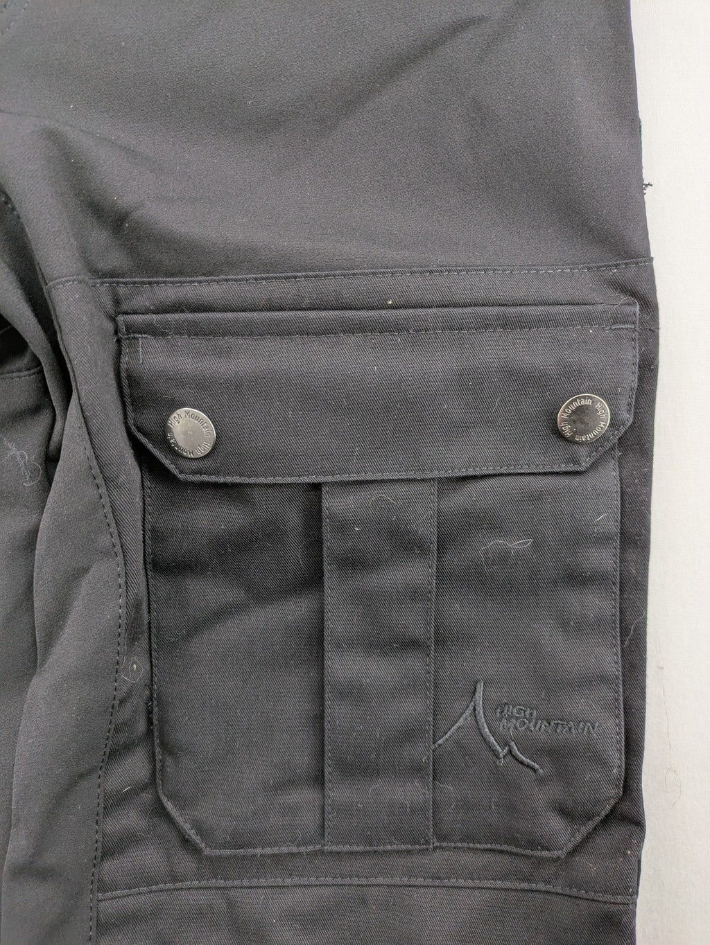 High Mountain black cargo pants with multiple pockets and durable stretch material.