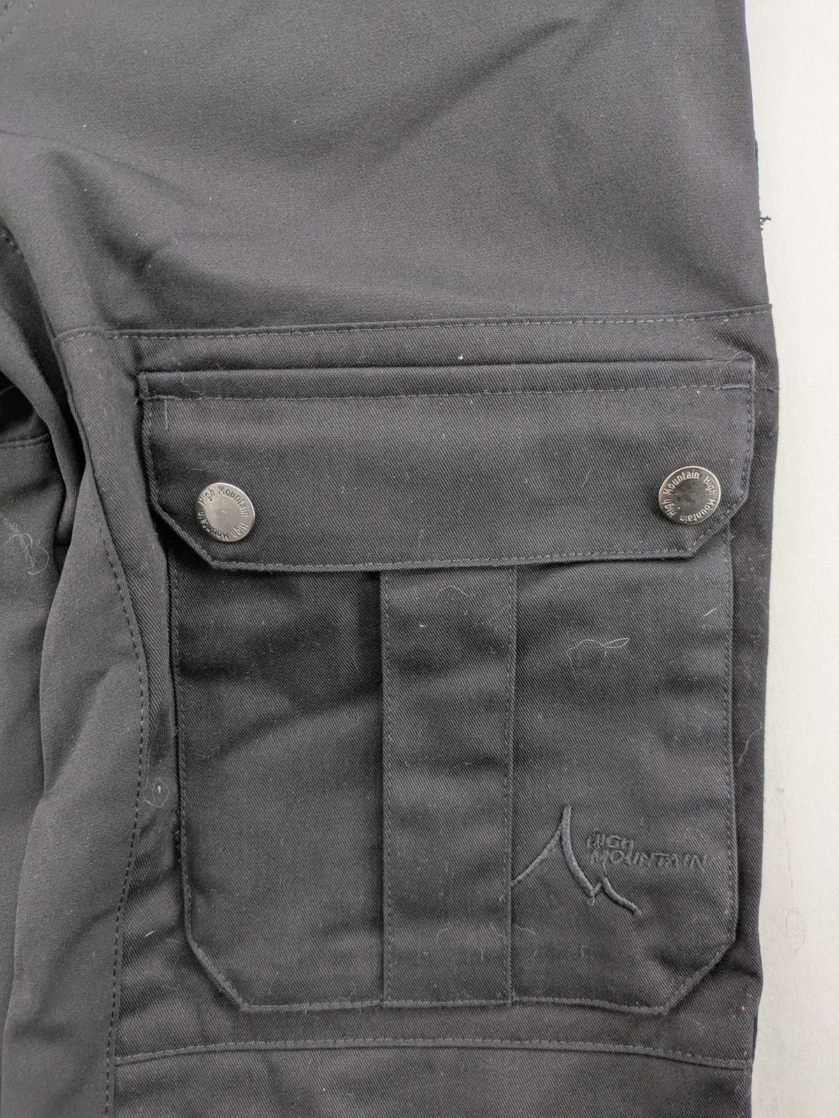 High Mountain black cargo pants with multiple pockets and durable stretch material.