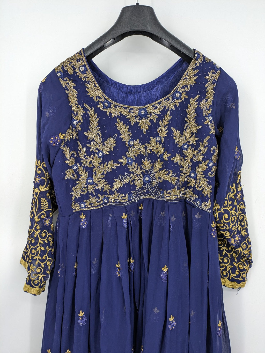 Bollywood bridal party dress gold with intricate blue embroidery and flowing Anarkali silhouette.