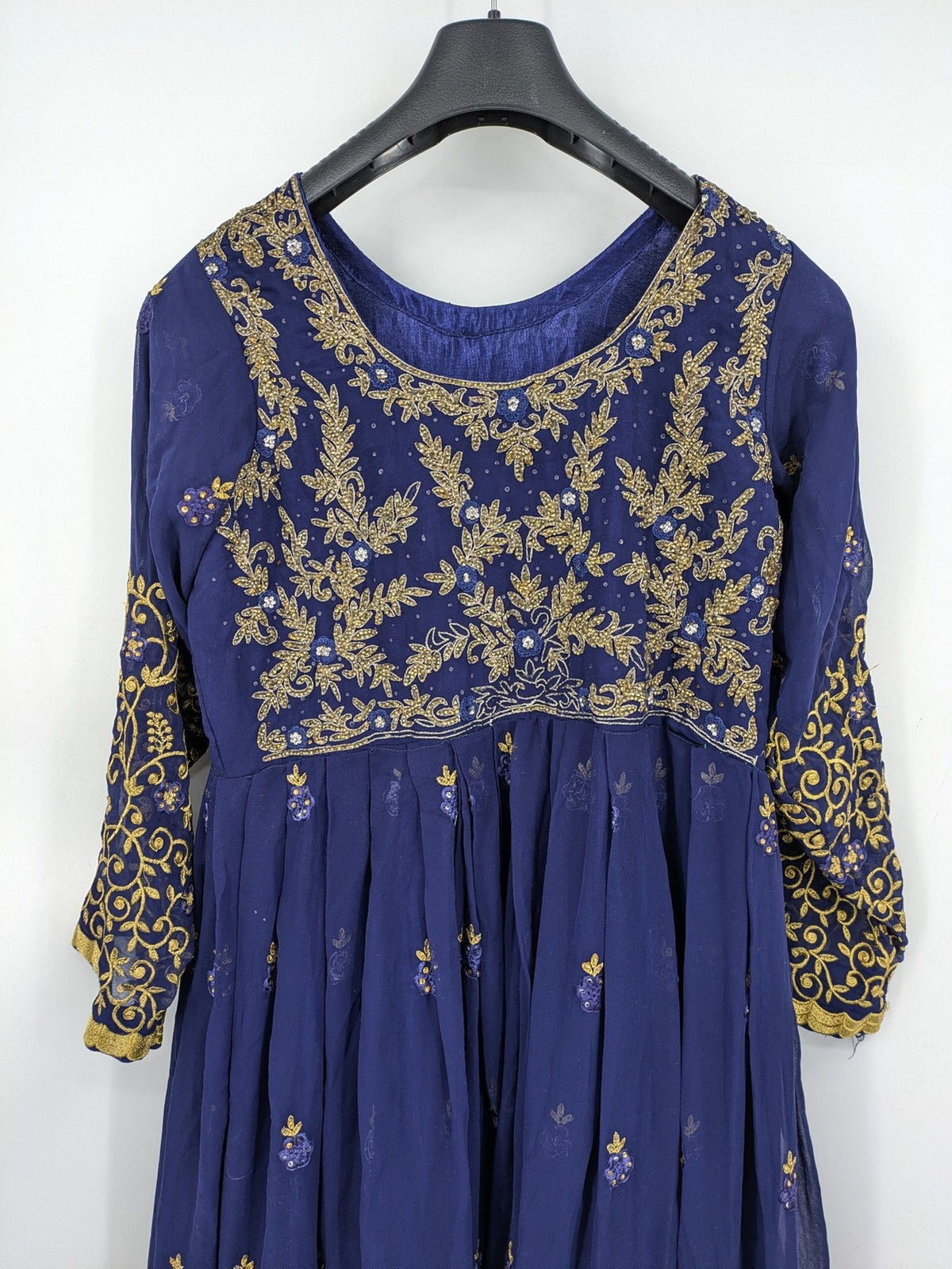 Bollywood bridal party dress gold with intricate blue embroidery and flowing Anarkali silhouette.