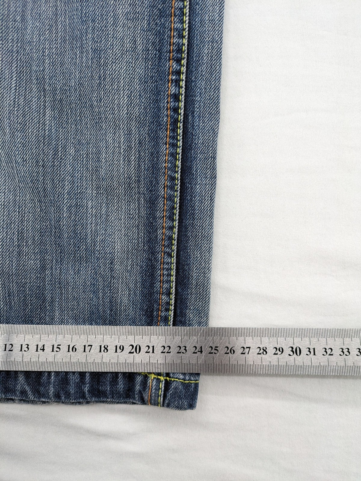 Identic orange straight jeans with paneled design and contrasting yellow stitching.