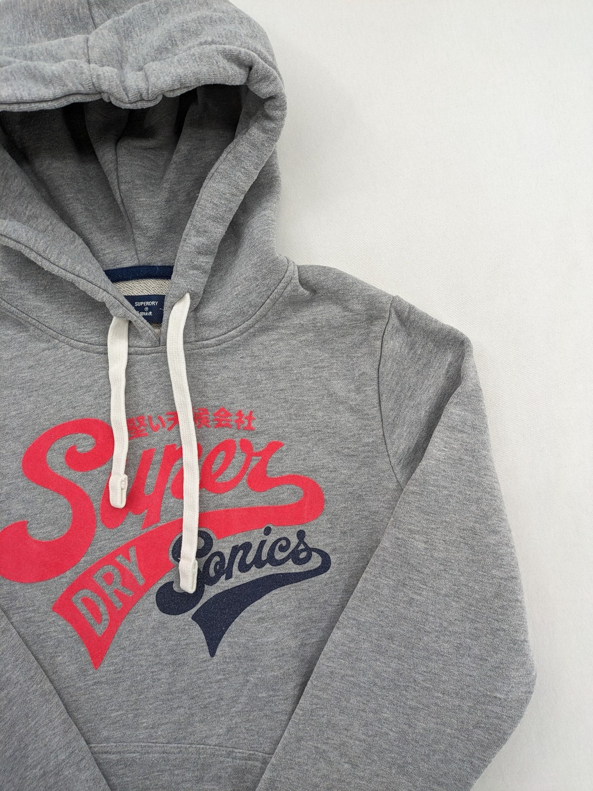 Superdry grey hoodie with Sonics logo, number 7 detail, kangaroo pocket, and drawstring hood.