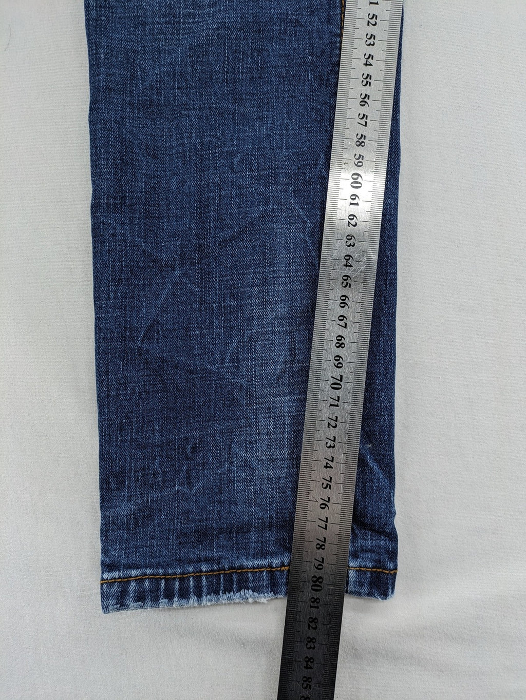 Soda blue straight jeans with distressed rips and button fly, cotton blend material.