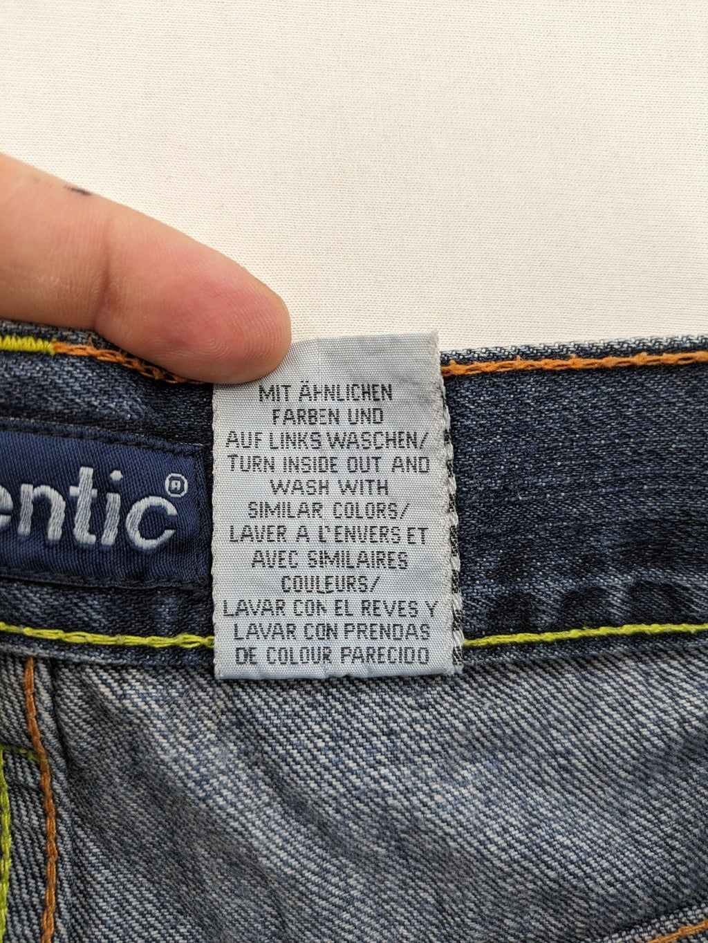 Identic orange straight jeans with paneled design and contrasting yellow stitching.