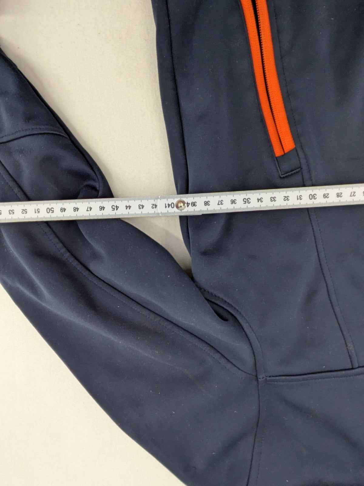 Crane navy softshell jacket with fleece lining, full zip, orange accent zippers.