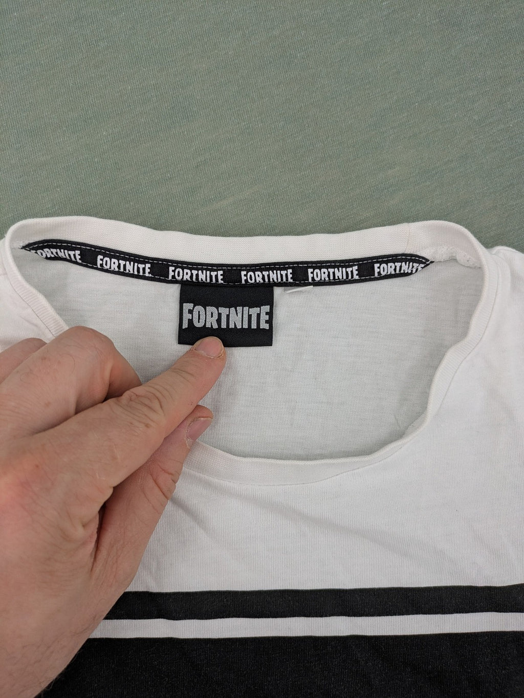 Fortnite white t-shirt with black chest stripe and Epic Games logo, 100% cotton.
