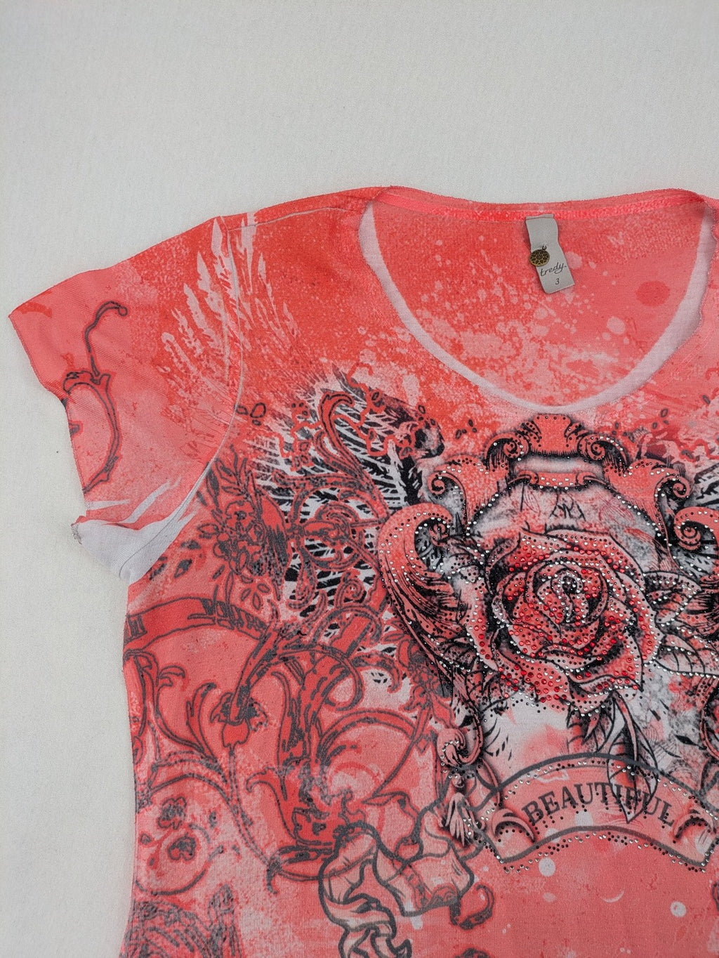 TREDY pink graphic top with rose and wings design, embellished with rhinestones.