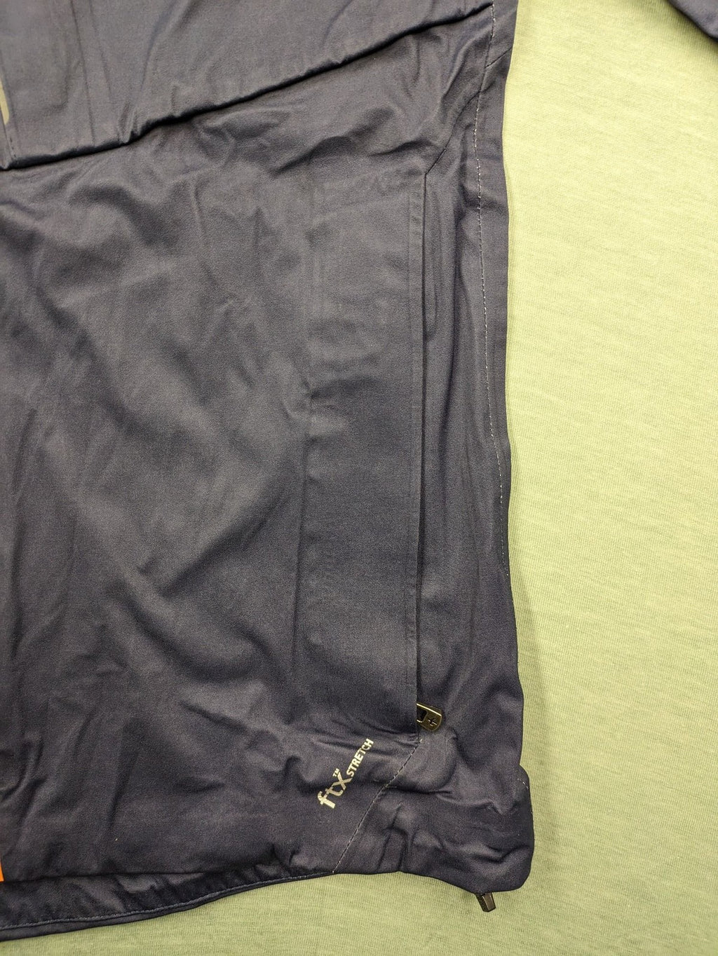 Cross Sportswear orange golf jacket with full zip, high collar, and contrast zipper details.