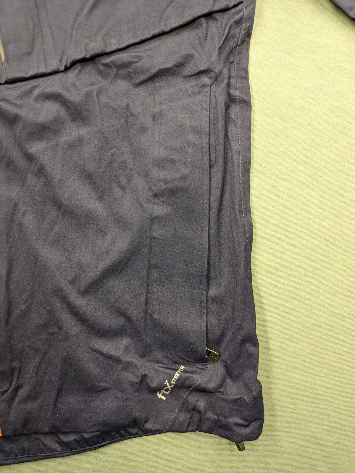 Cross Sportswear orange golf jacket with full zip, high collar, and contrast zipper details.