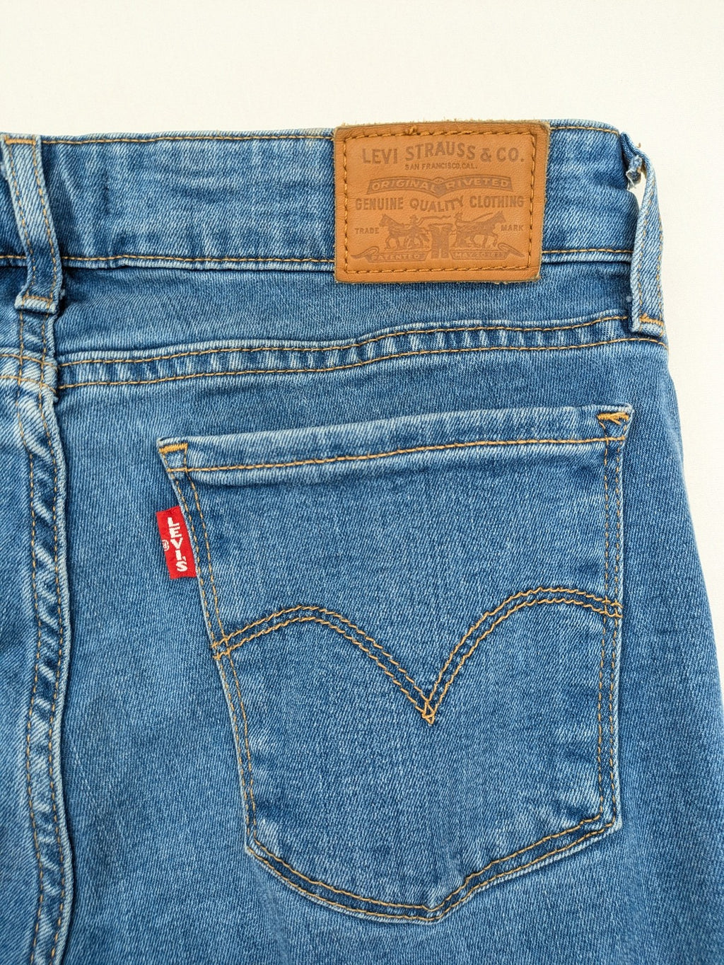 Levi's blue skinny jeans with raw hem, classic five-pocket design, and zip fly.