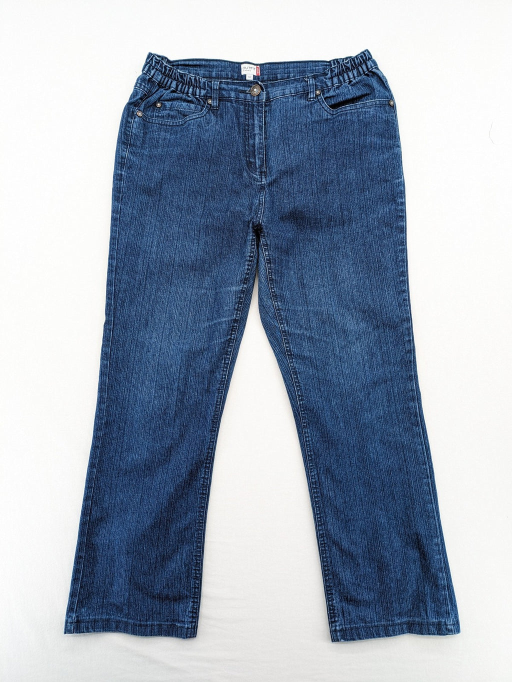 Outfit blue straight jeans with elastic waistband and embroidered crown-wing emblem on pockets.