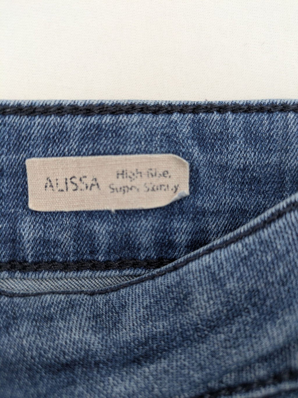 Mavi blue high rise super skinny jeans with medium wash and stretch denim material.